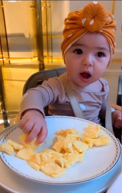 A bebê usava um lindo turbante laranja com bolinha brancas