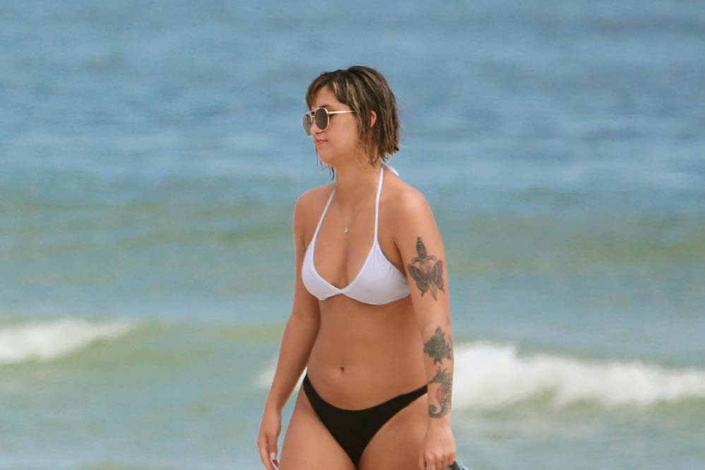 Carol Junger, namorada de José de Abreu, curte praia na Barra da Tijuca e mostra corpão.
