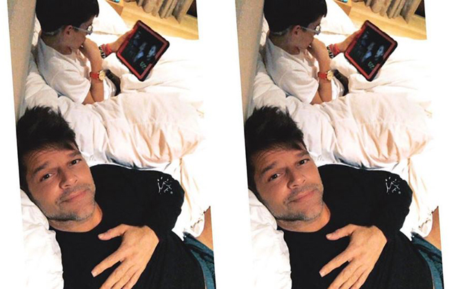 Ricky Martin implora a atenção de um dos gêmeos, que o ignora para jogar games eletrônicos 