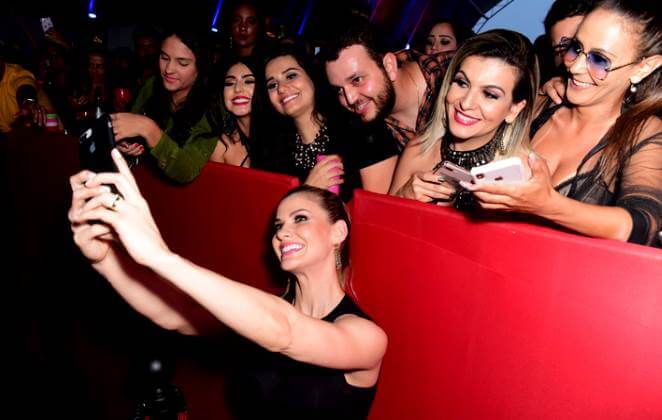 Andressa Suíta posando para fotos com fãs, na plateia do Caldas Country