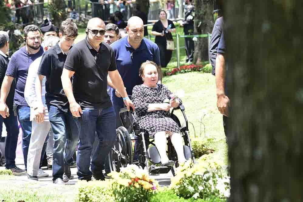 De cadeira de rodas, dona Maria do Céu, mãe de Gugu Liberato, marcou presença no sepultamento do renomado apresentador