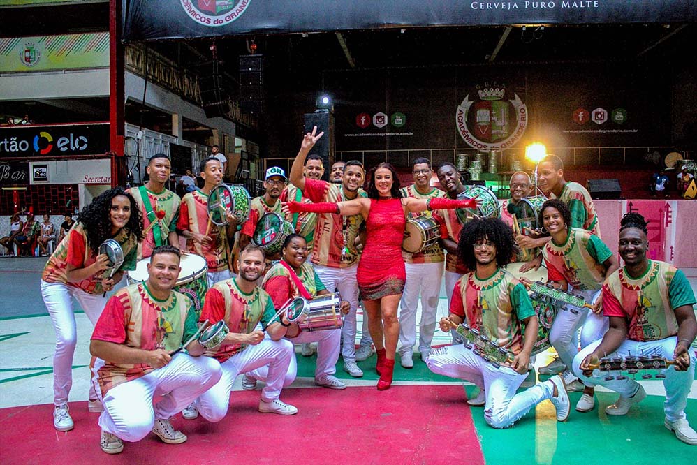Simpática, a atriz posou ao lado da bateria da escola, que apresenta o samba Tata Londirá: o Canto do Caboclo no Quilombo de Caxias no Carnaval de 2020.
