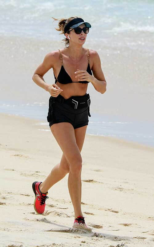 Grazi Massafera deixa fina silhueta à mostra ao correr na praia