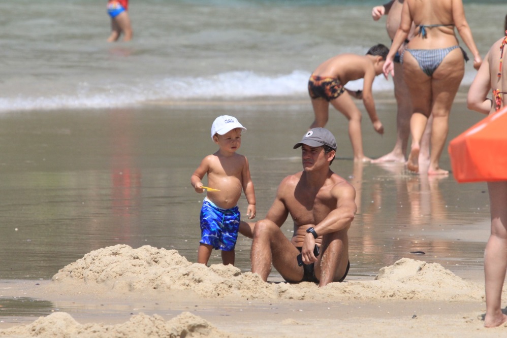 Paulo Rocha exibe corpão em dia de praia com o filho