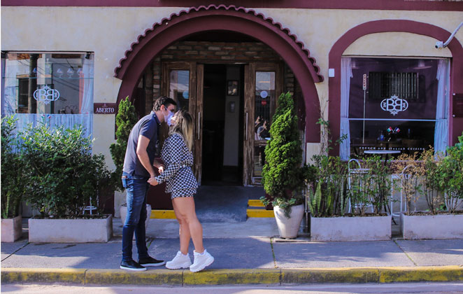 Ana Paula Minerato e namorado trocam selinho em frente ao restaurante