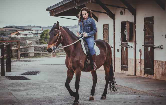 Nubia Oliiver andando a cavalo em haras