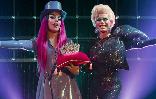 Alexia Twister e Gloria Groove segurando uma coroa de prêmio em cena de Nasce Uma Rainha