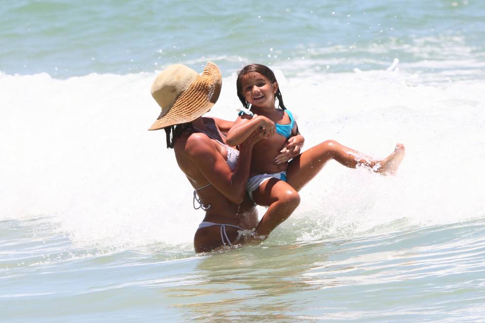 Deborah Secco ajuda a filha Maria Flor a pular ondas na Barra da Tijuca