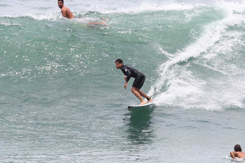 Cauã Reymond surfa em praia carioca