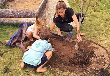 Gisele Bündchen planta árvores com os filhos