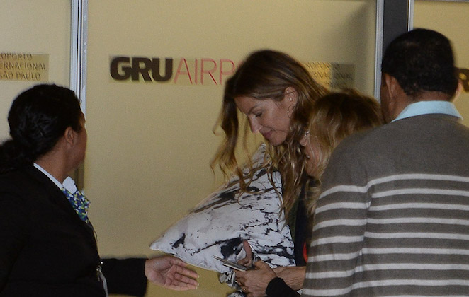 Gisele Bündchen se escondndo com travesseiro em aeroporto
