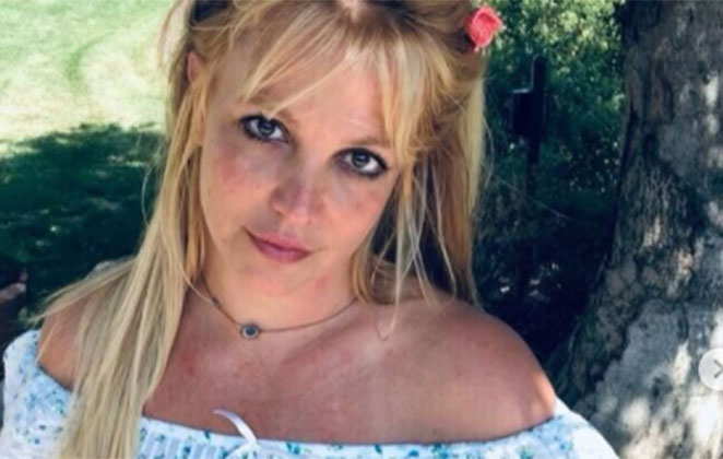 Britney Spears no jardim, com os cabelos amarrados