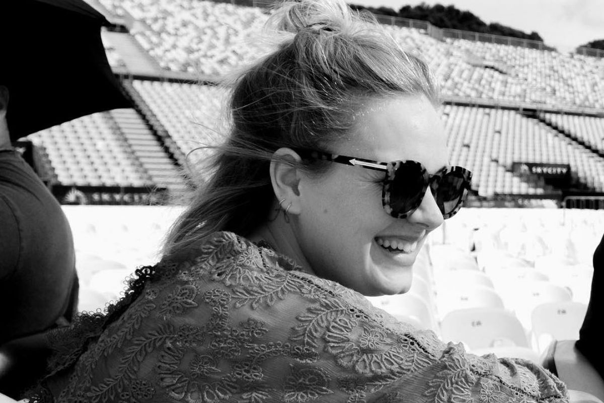 Adele sorrindo e de óculos escuros