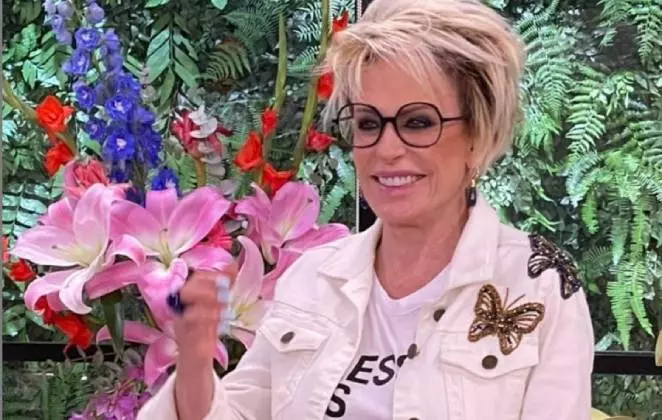 Ana Maria Braga segurando uma flor