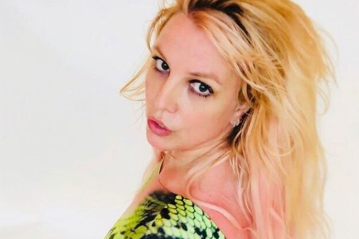 Britney Spears com look animal print olhando para a câmera