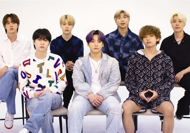 O grupo BTS sentados em fileiras para entrevista