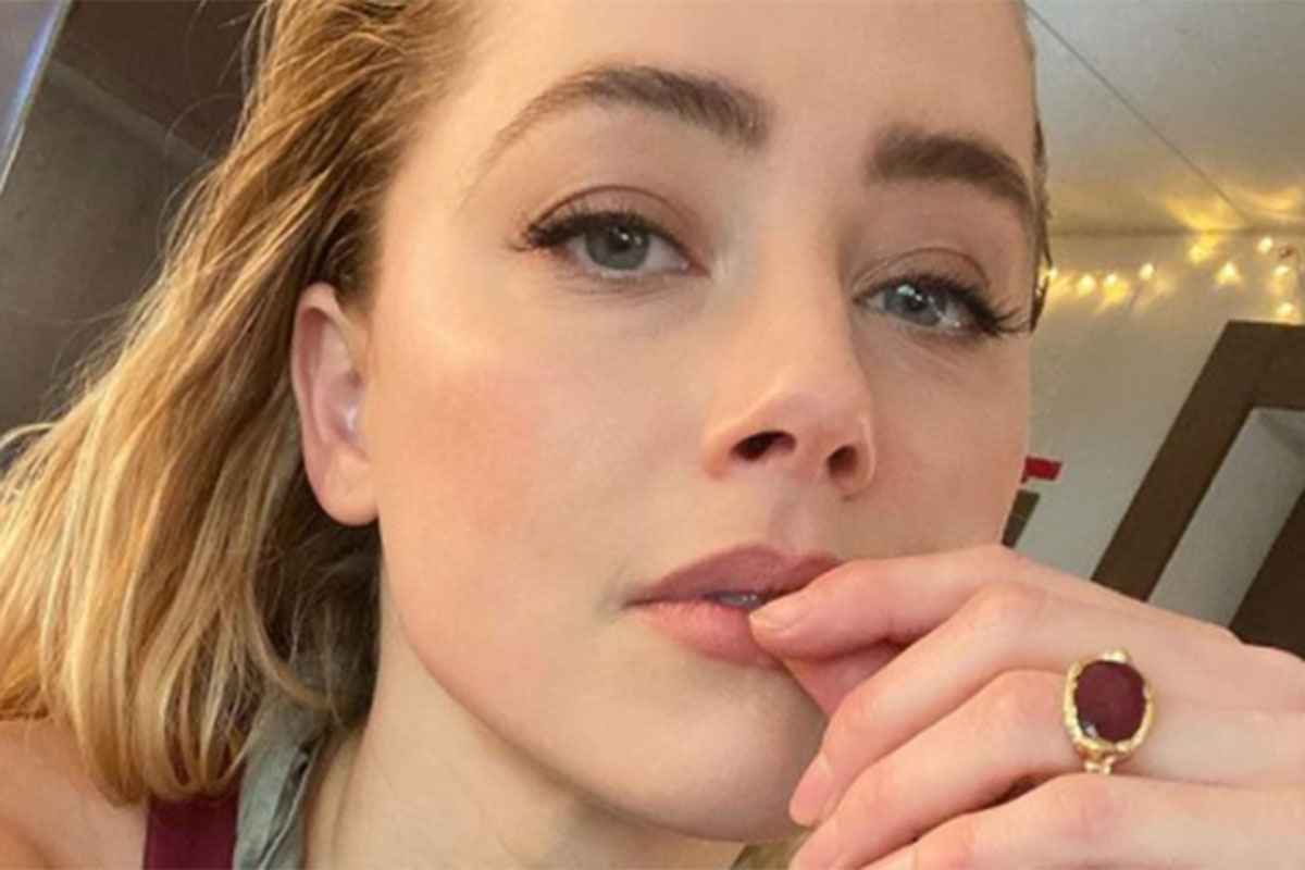 Amber Heard faz selfie com a mão nos lábios