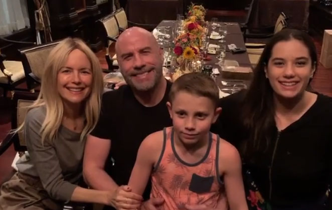Kelly Preston, com John Travolta e os filhos do casal, sentados à mesa