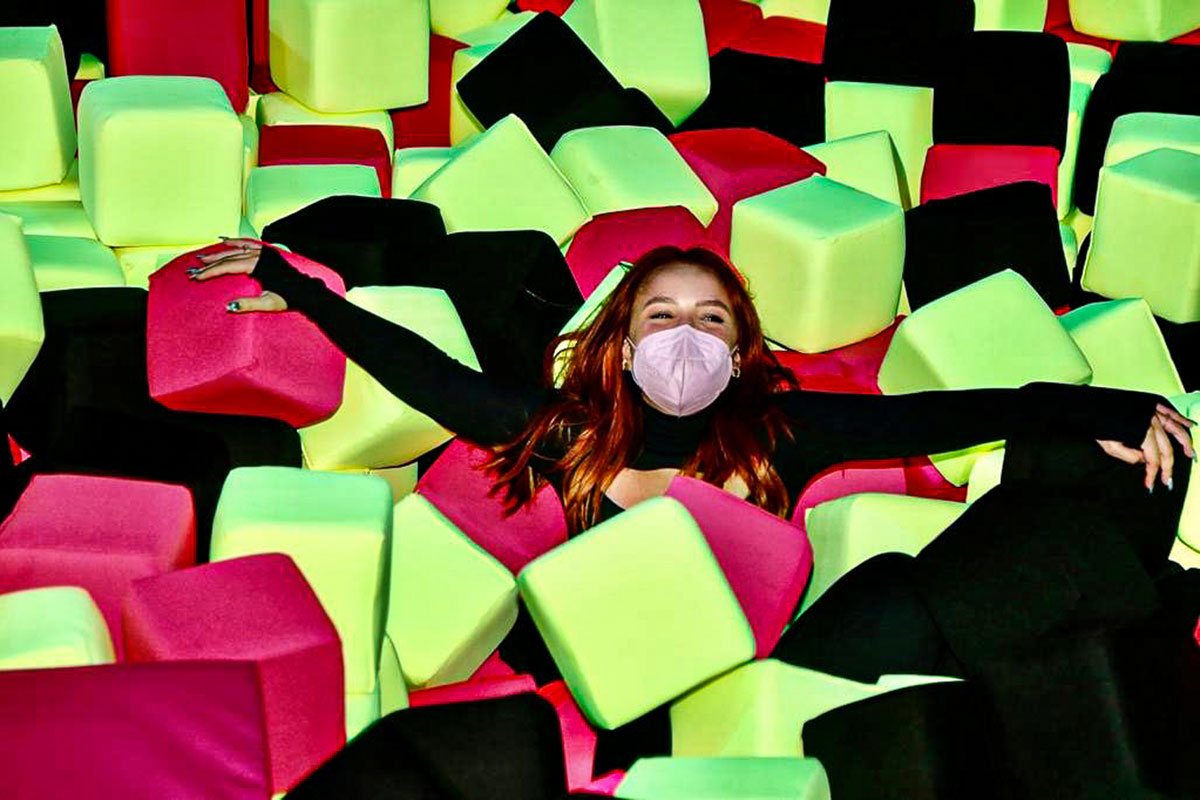 Larissa Manoela de máscara, deitada em blocos coloridos