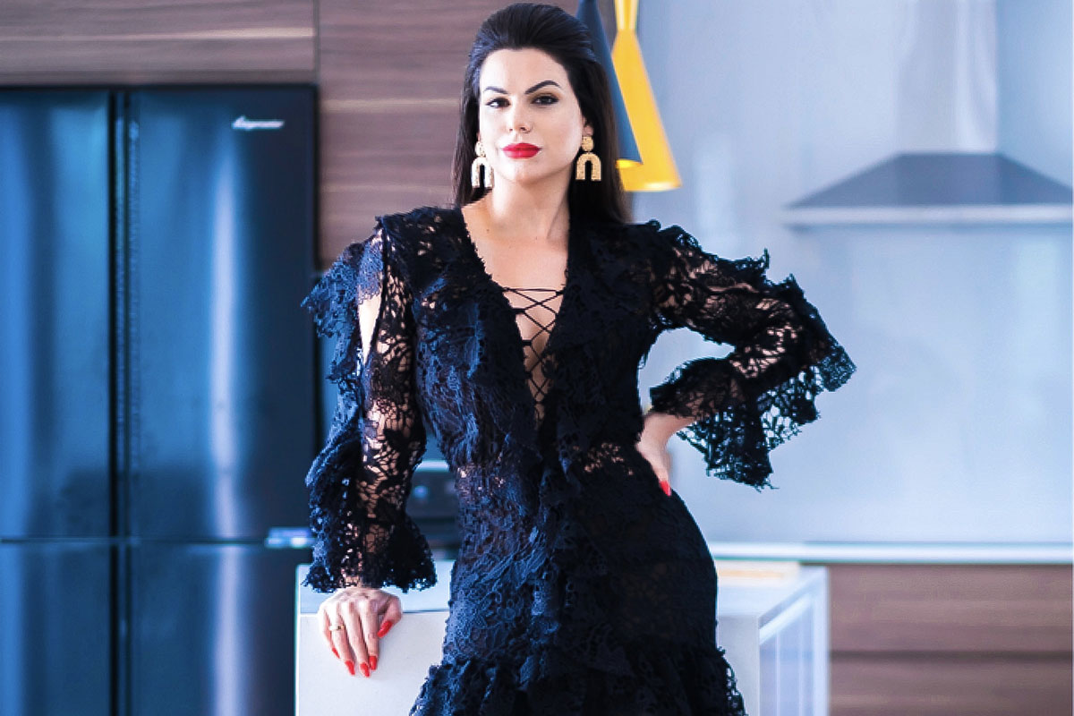 A modelo trans Camila Mantovani elegante, com um vestido preto rendado