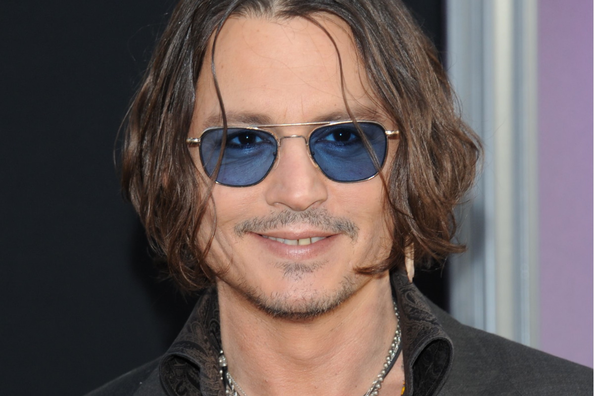 Johnny Depp sorrindo e de oculos