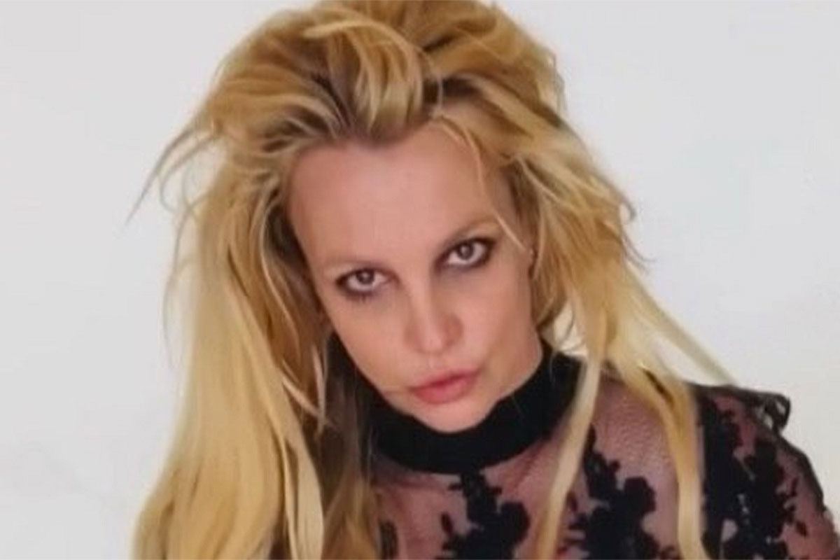 Britney Spears com os cabelos despenteados e blusa transparente