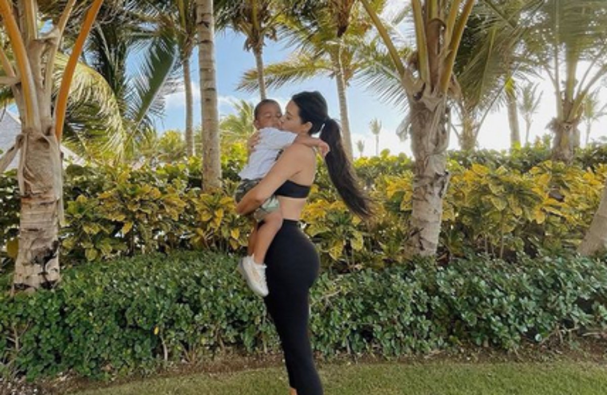 Kim Kardashian beija o filho Saint em um jardim