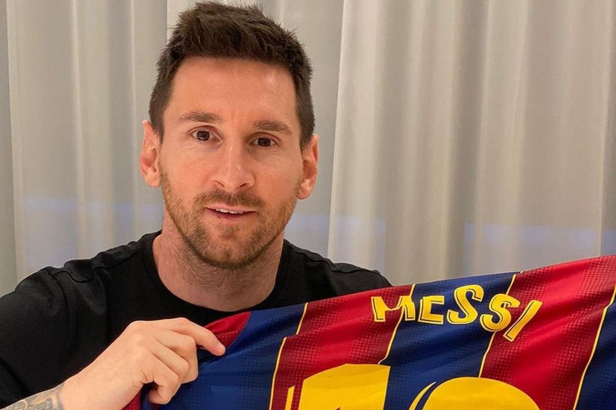 Foto de Lionel Messi sorrindo e segurando uma camiseta do Barcelona