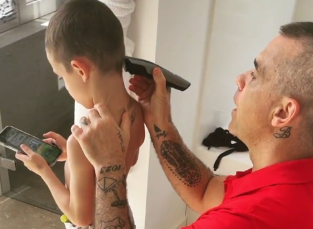 Robbie Williams corta o cabelo do filho