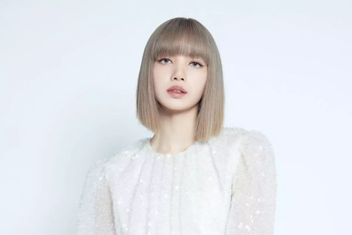 Lisa, do BLACKPINK, em foto com o cabelo chanel, loiro e ela olhando para a câmera