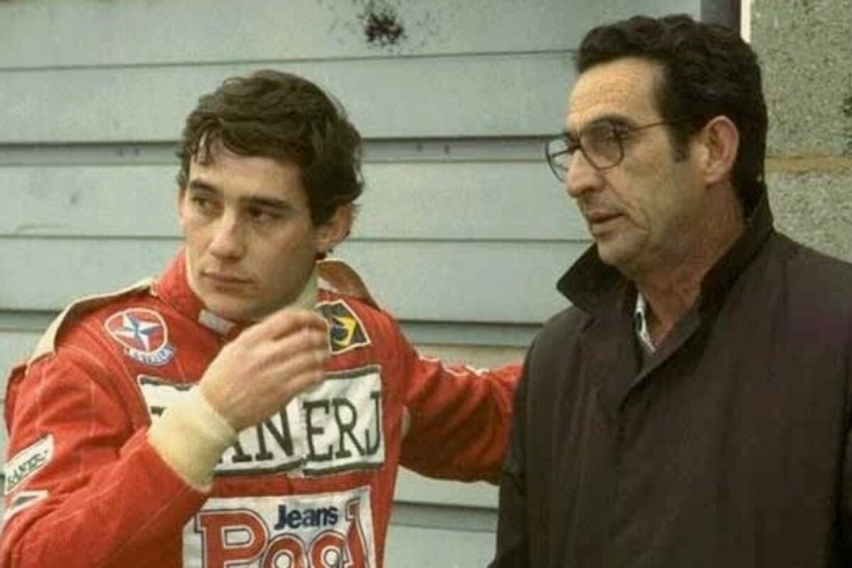 Ayrton Senna, de uniforme da F-1, conversando com o pai, que veste casaco marrom