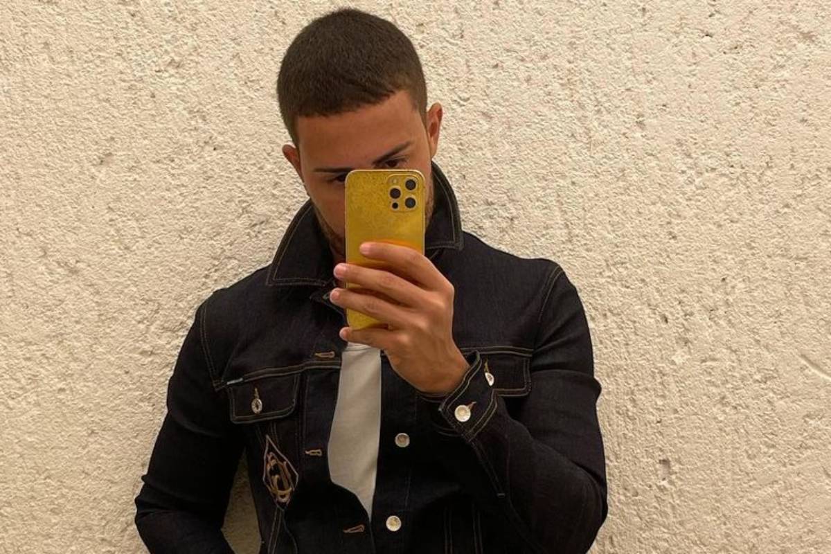 carlinhos maia tirando selfie com celular amarelo e usando jaqueta jeans preta