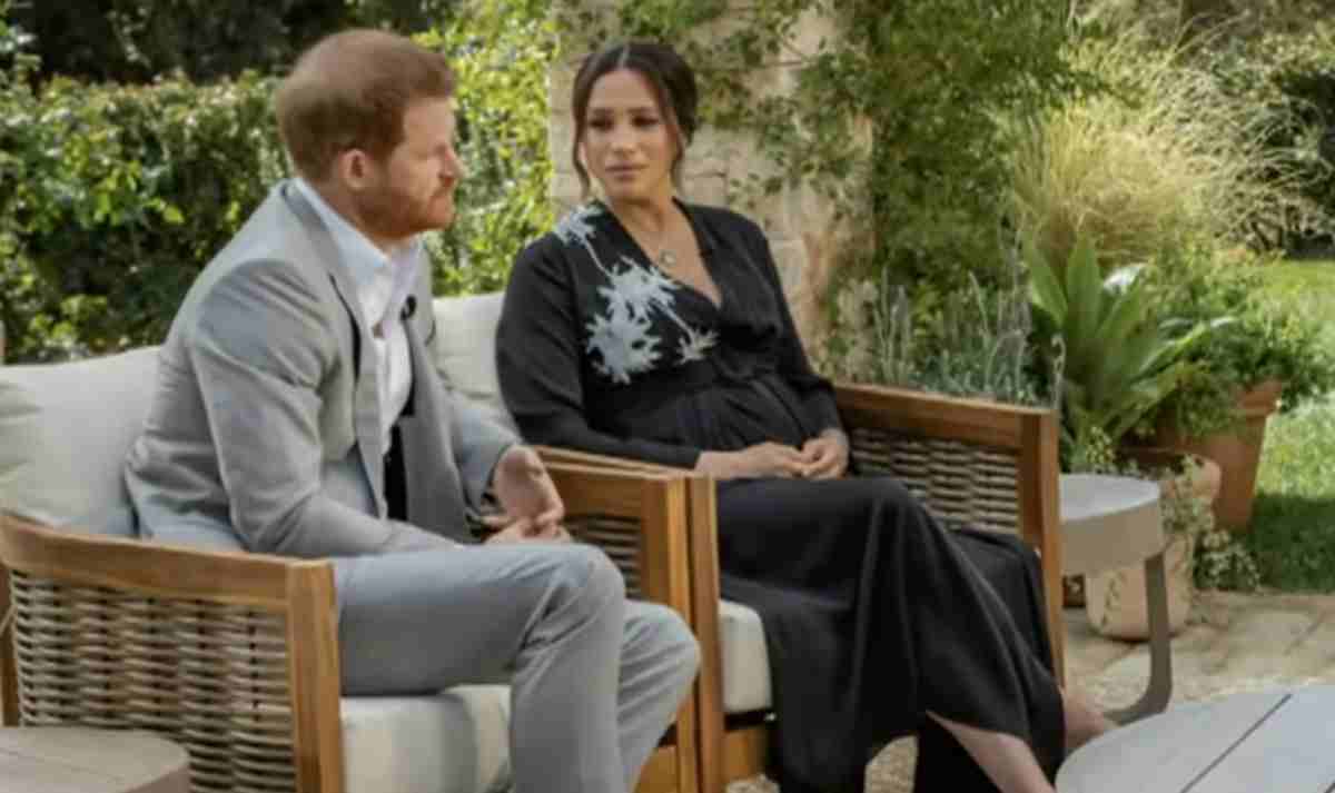 Príncipe Harry e Meghan Markle sentados no jardim