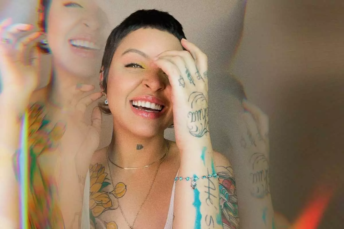 kell smith posando sorridente com efeito espelhado de prisma