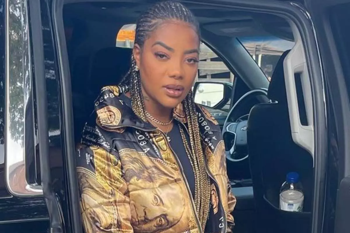 ludmilla posando séria em carro com jaqueta e tranças douradas