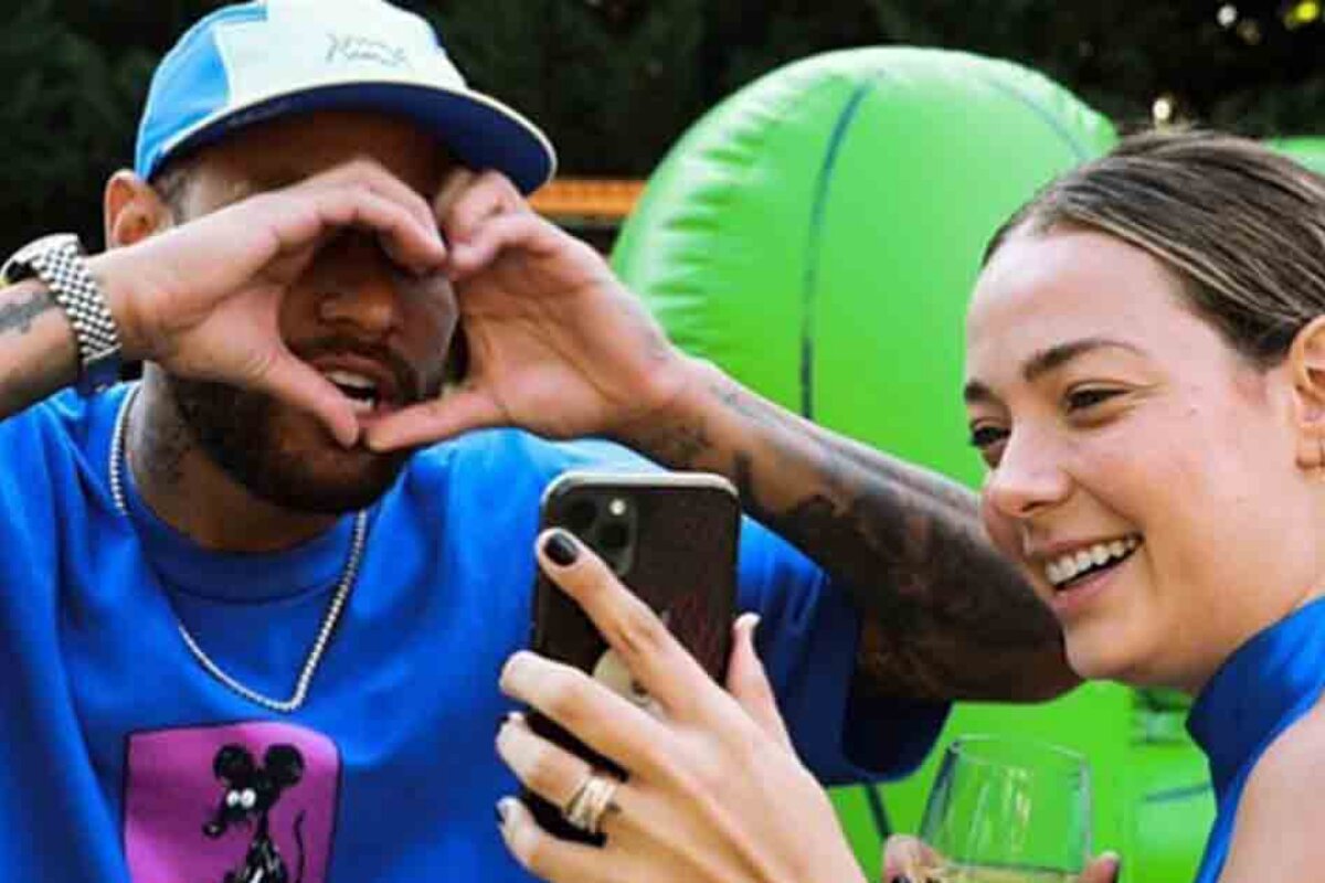 NEymar fazendo coraçãozinho com as mãos diante da ex-Carol Dantas, que tira foto