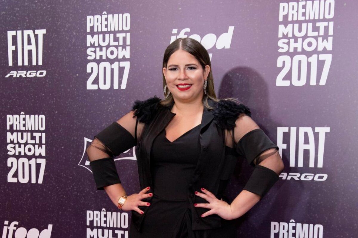 Marília Mendonça com as mãos a cintura, de vestido preto, no Prêmio Multishow em 2017