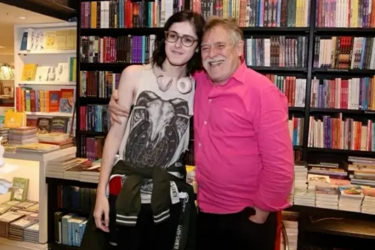 José de Abreu de camisa rosa e a filha trans, Bia, numa livraria