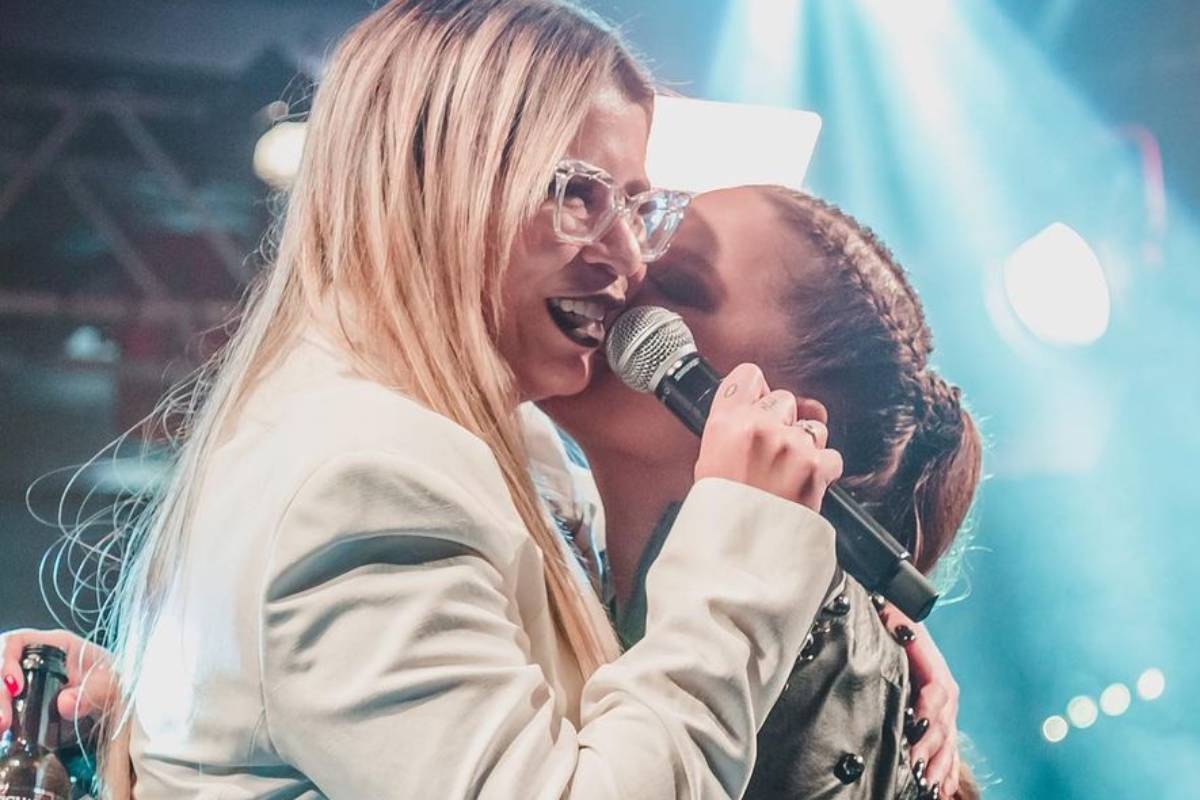 maiara beiajndo bochecha de marilia mendonça enquanto a mesma canta no palco