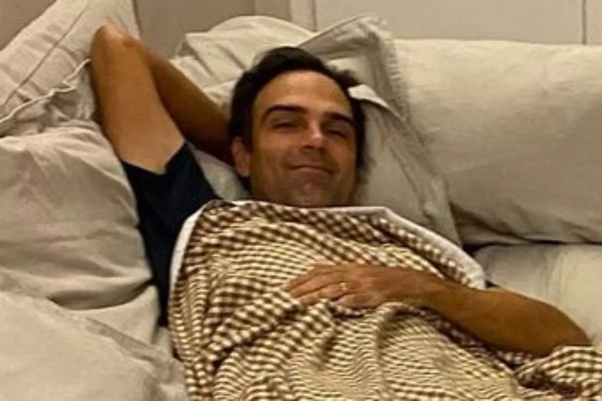 tadeu schmidt deitado no sofá com um cobertor