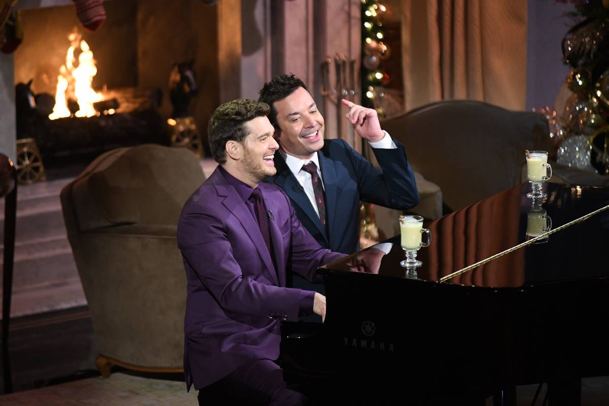 cena do show especial de natal com michael bublé tocando piano com jimmy fallon ao lado