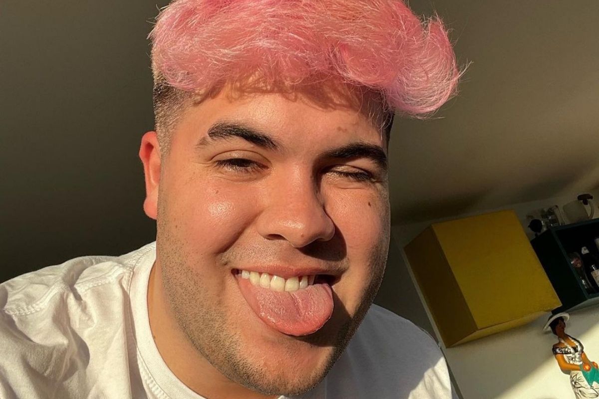 Alvaro em selfie com o cabelo rosa e mostrando a língua