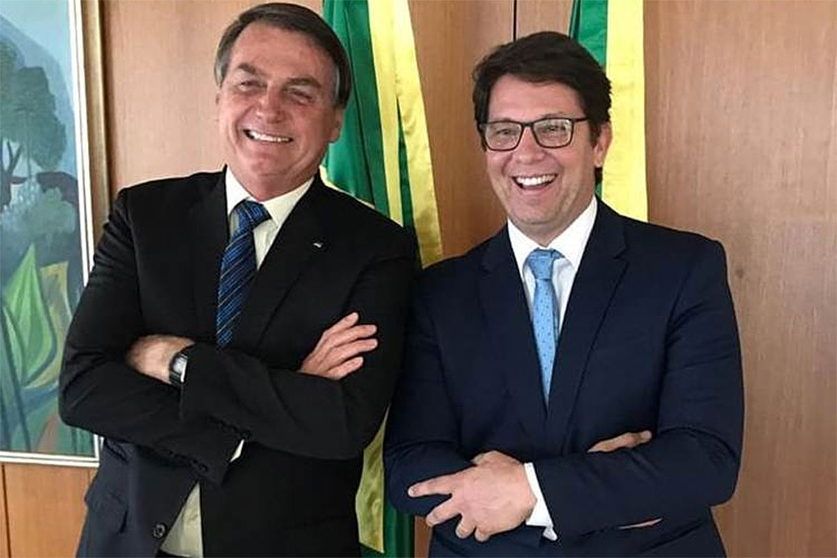 Presidente Jair Bolsonaro e Mário Frias, de braços cruzados e rindo