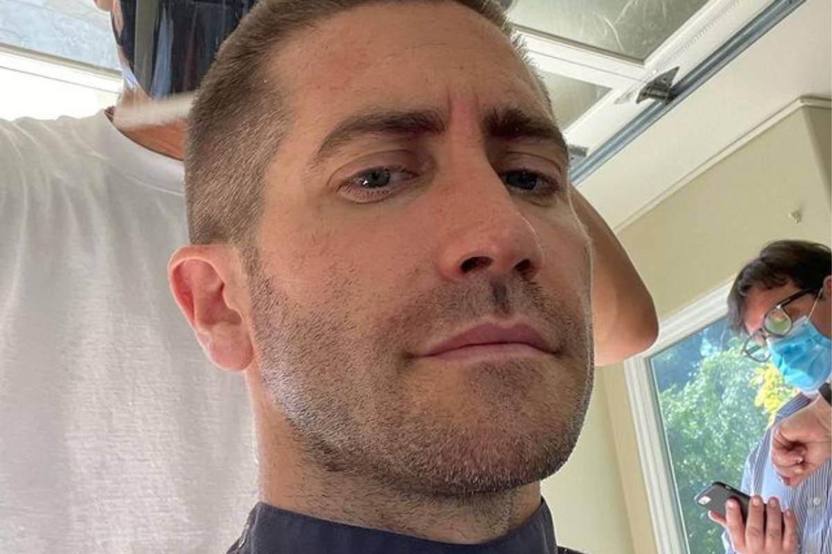 jake gyllenhaal posando sério enquanto ajeita o cabelo