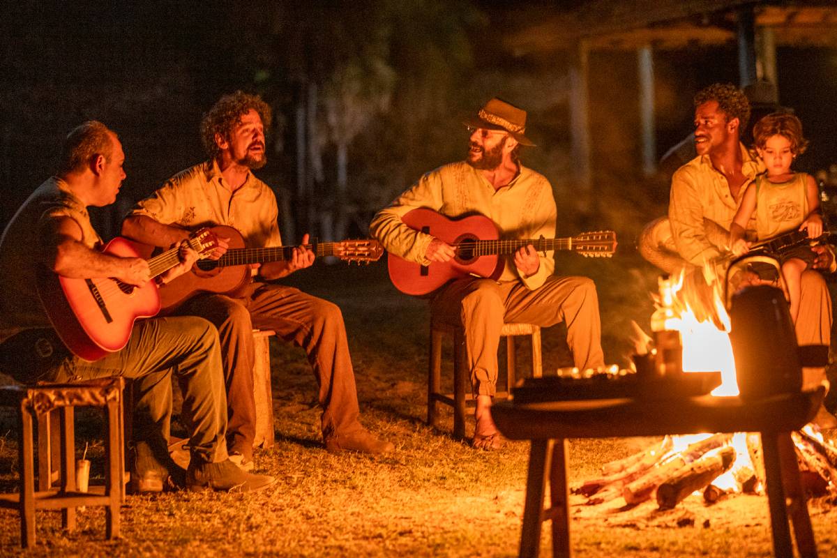 Quim (Chico Teixeira), Eugênio (Almir Sater) e Tião (Fábio Neppo), com Tadeu (Lucas Oliveira dos Santos) cantando envolta da fogueira em Pantanal