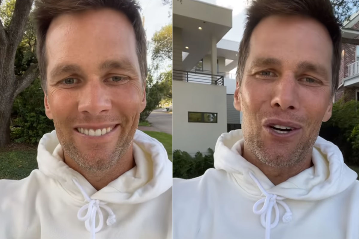 Tom Brady com blusão branco, sorridente
