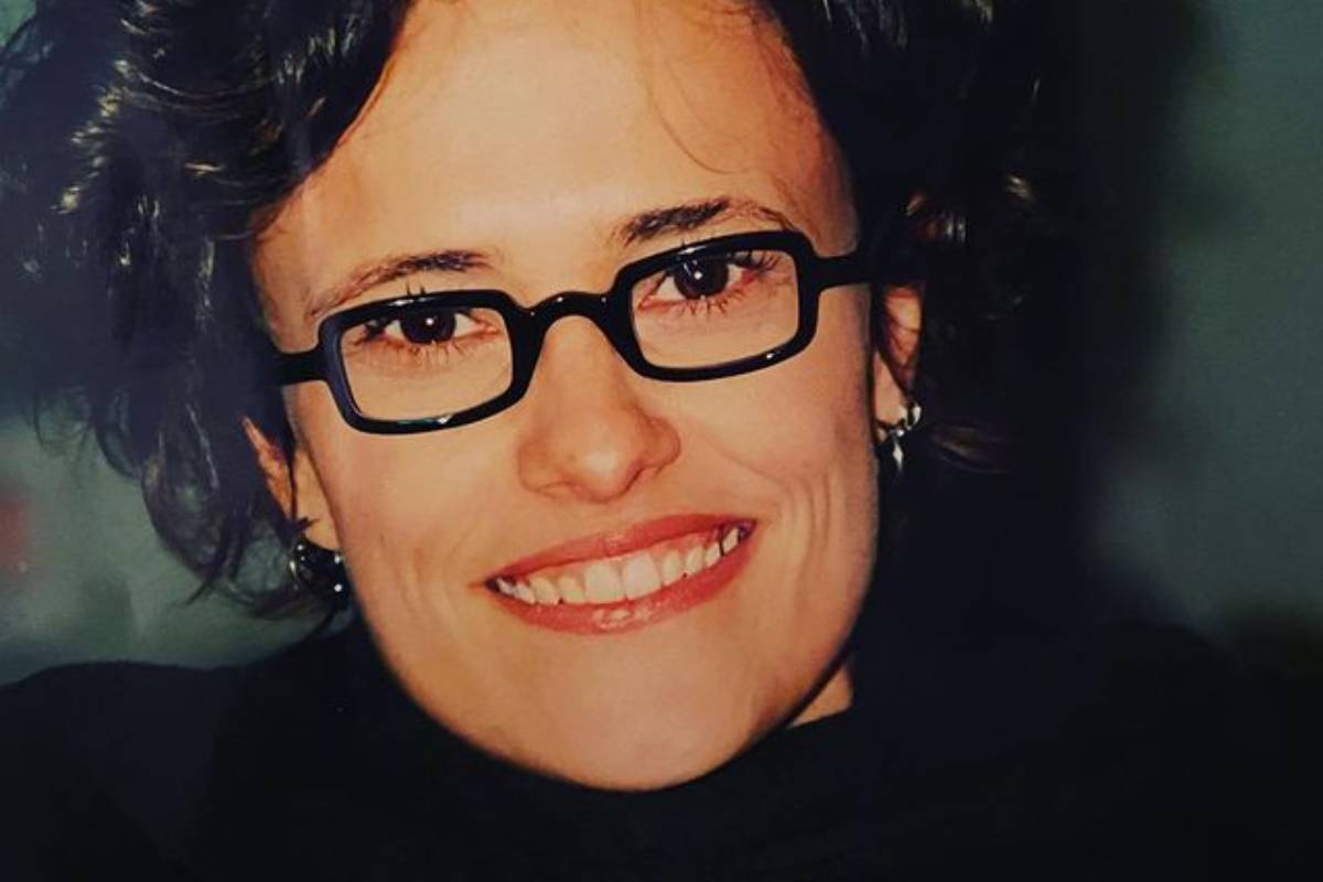 Zélia Duncan posando de óculos preto e sorridente