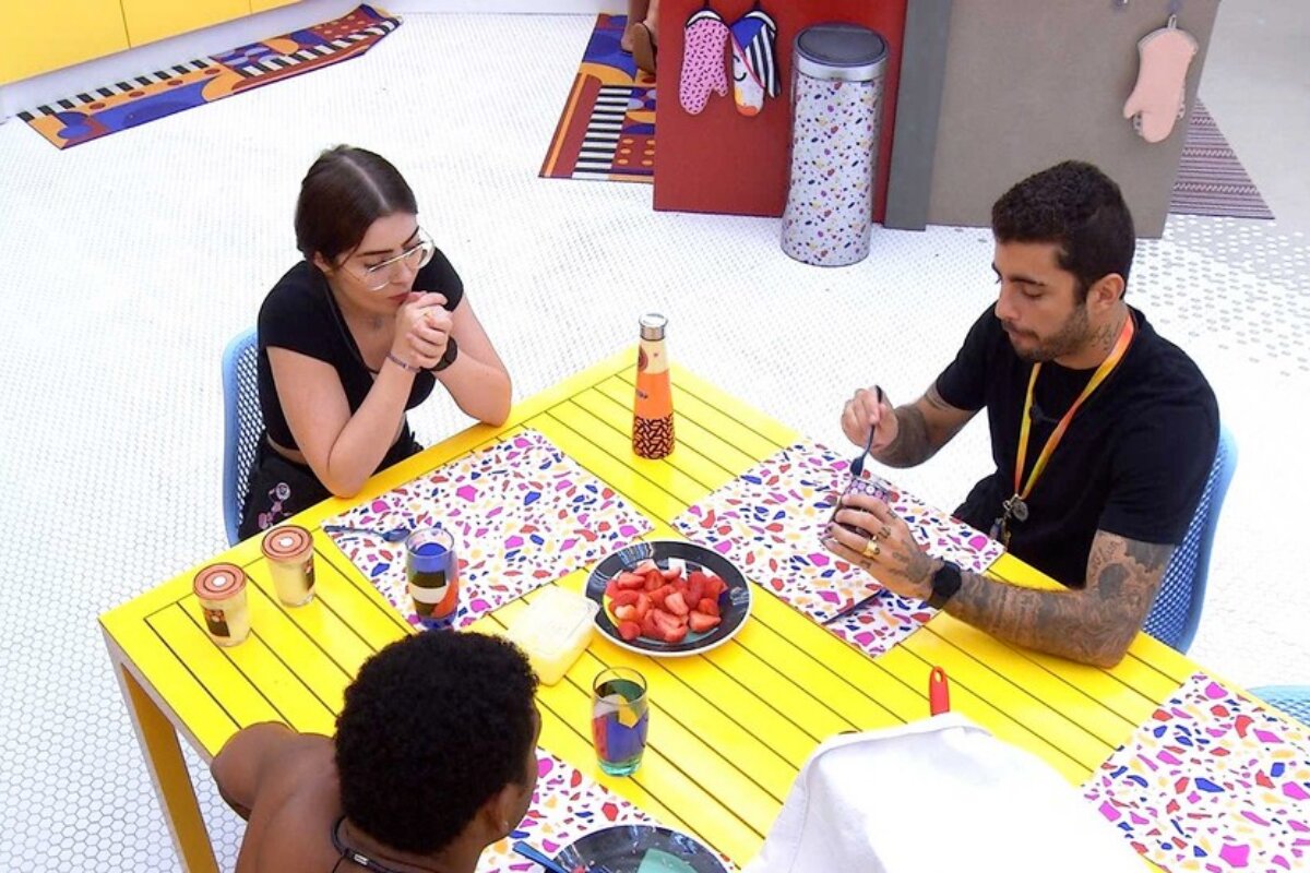 Jade, Paulo André e Scooby sentados à mesa do vip