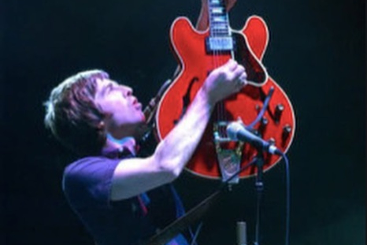 noel gallagher tocando guitarra vermelha em show antigo