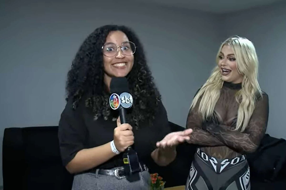 Luisa Sonza sendo entrevistada por repórter do SBT, ambas de preto